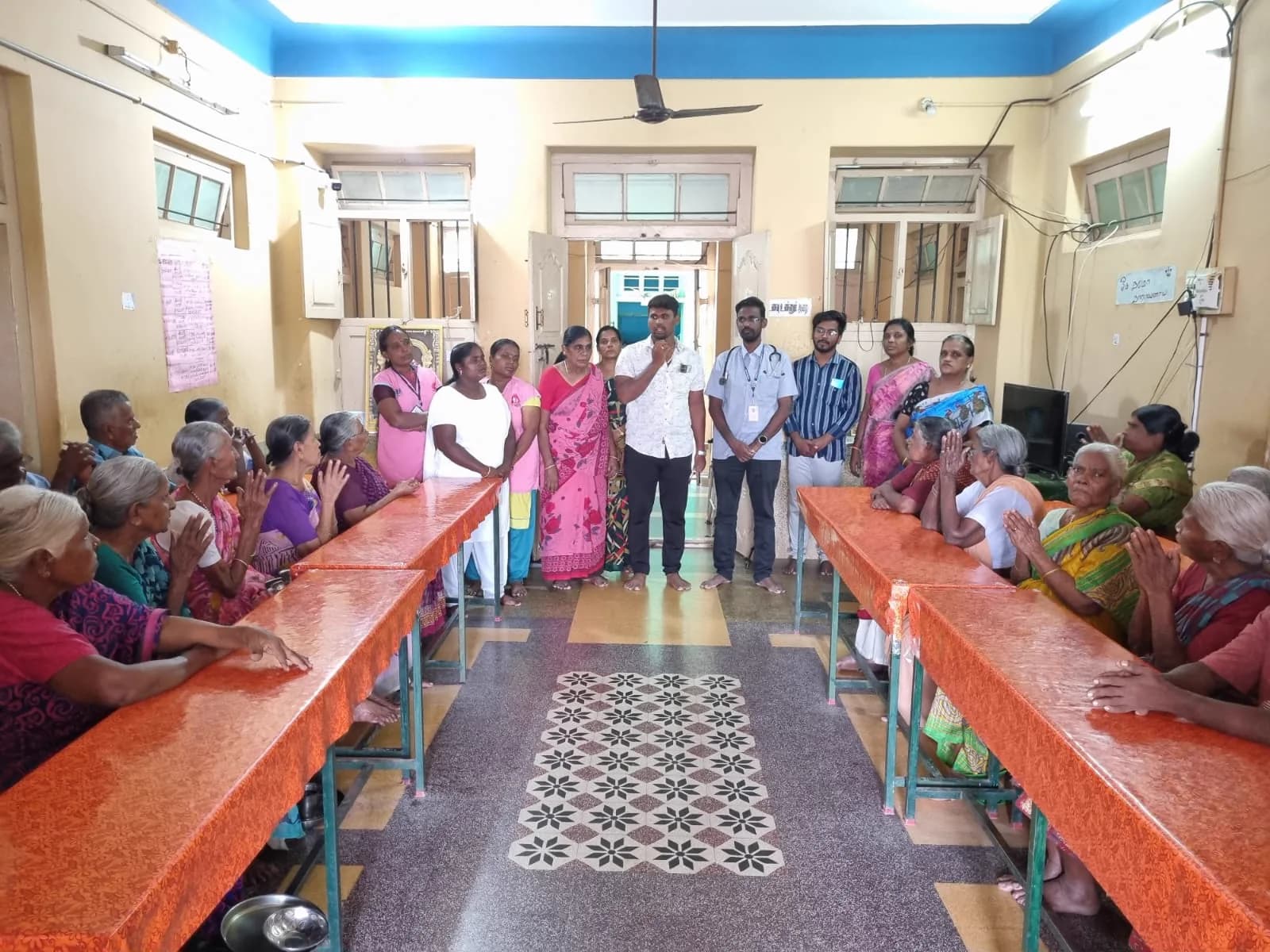 Residents seated at long tables for a meal